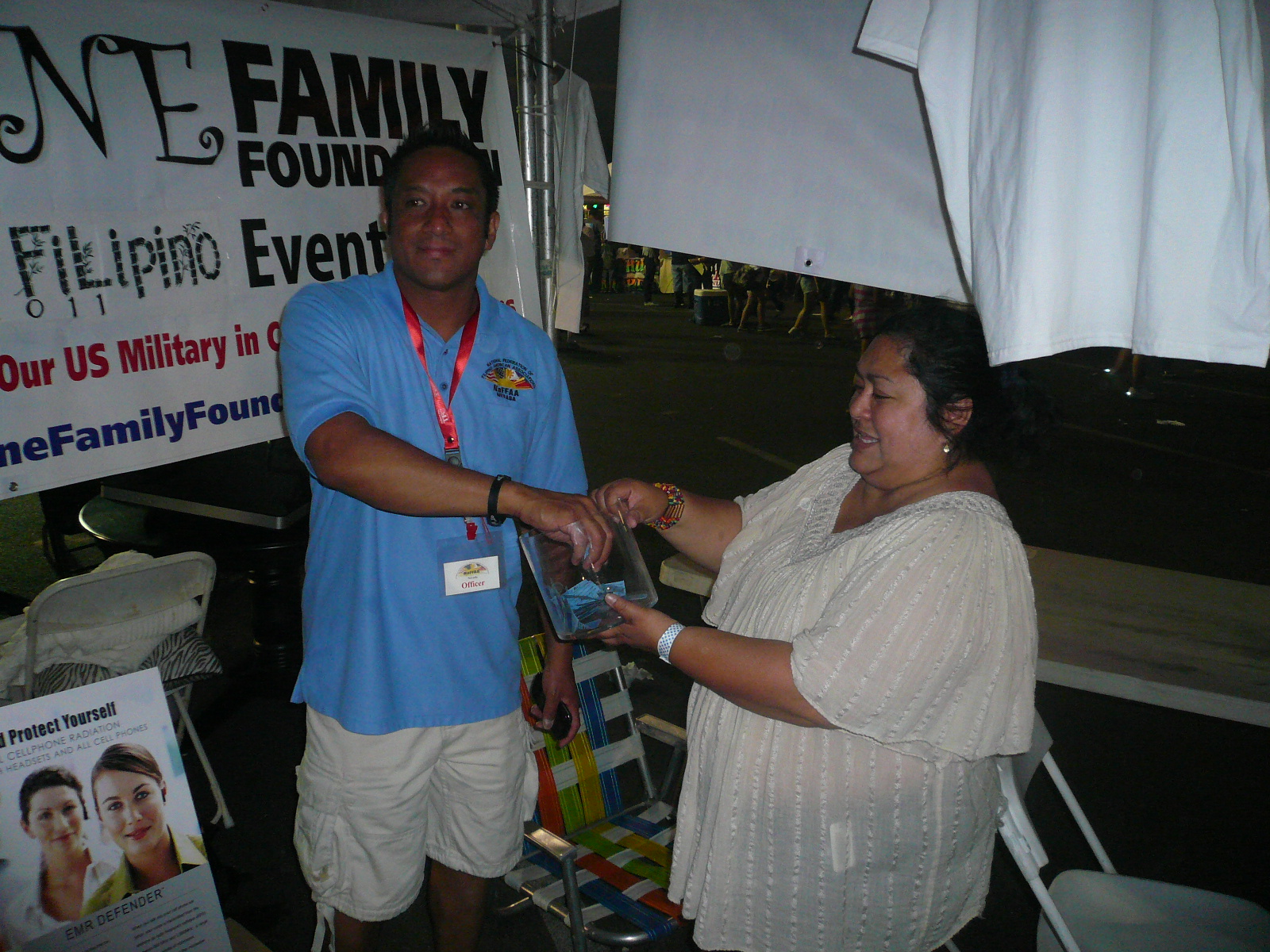 Vilma Gorre (community outreach coordinator of Shine Family Foundation) with Noel Cassimiro drawing winner of a man\'s gold bracelet donated by New York Diamond Exchange